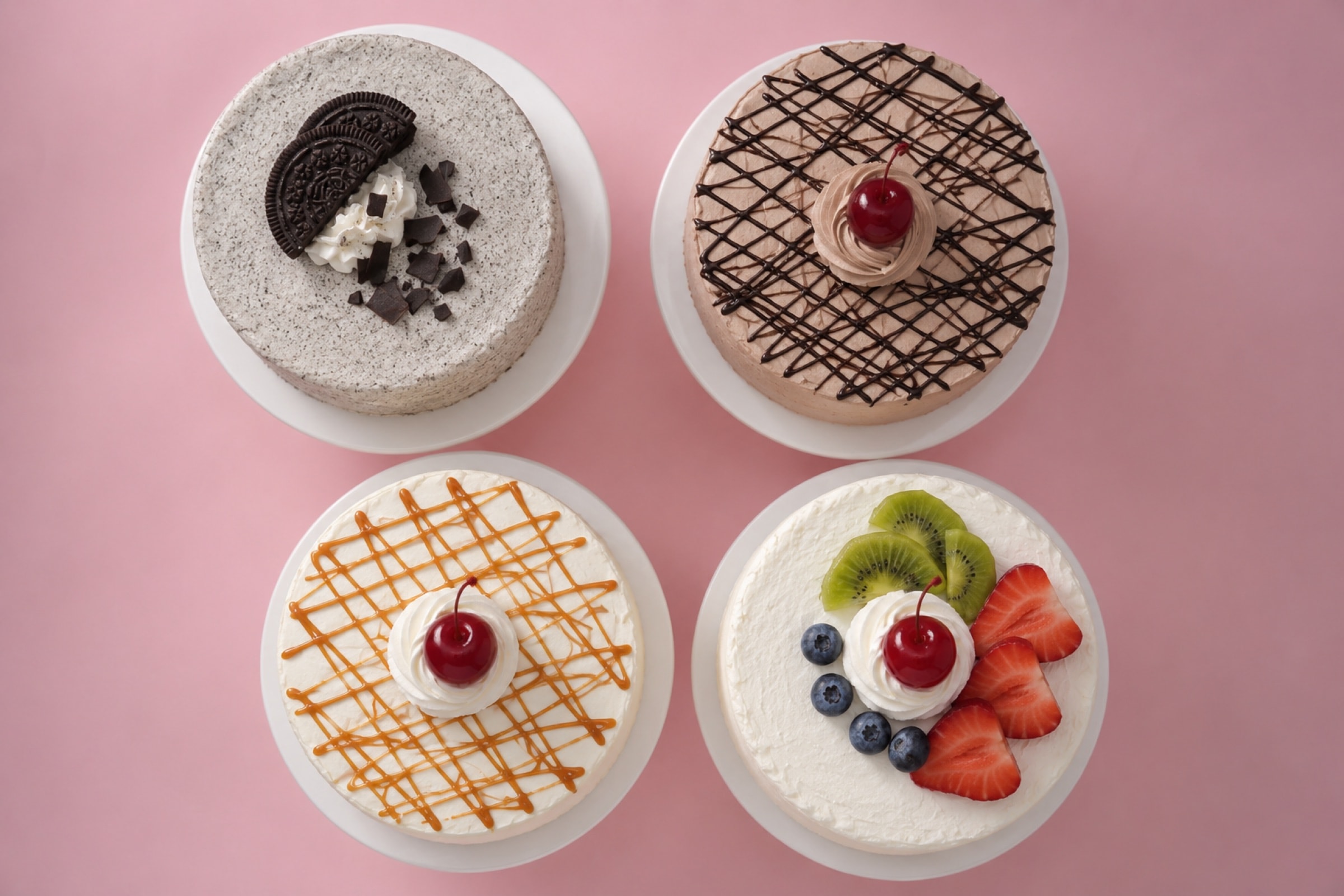Whole celebration cakes decorated with fresh fruit and cherries